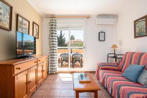 a living room with a couch and a tv at Jardín del Golf2 9 1A in Novo Sancti Petri