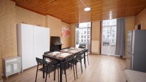 a dining room with a table with chairs and a refrigerator at Plantin Apartment in Antwerp
