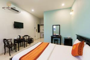 a bedroom with a bed and a desk and a television at Nét Việt House Hotel Market & Bridge Centre Soc Trang in Soc Trang