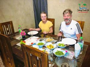 a man and woman sitting at a table with food at Sinharaja Cascade Villa in Deniyaya +7 photos