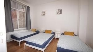 a room with two beds and a window at Plantin Apartment in Antwerp