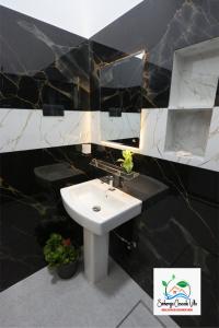 a black and white bathroom with a sink and a mirror at Sinharaja Cascade Villa in Deniyaya