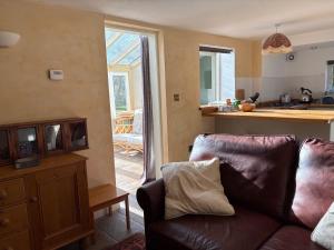 a living room with a couch and a kitchen at The Old Post Office, Hilton in Huntingdon
