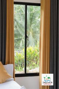 a window with a view of a tree at Sinharaja Cascade Villa in Deniyaya