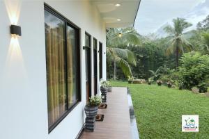 a porch of a house with potted plants on it at Sinharaja Cascade Villa in Deniyaya