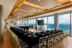 a long table with chairs in a room with the ocean at Hilton Cancun Mar Caribe All-Inclusive Resort in Cancún +131 photos