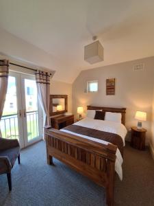 a bedroom with a large bed and a large window at Doolin Court in Doolin