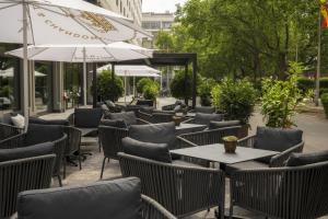 an outdoor restaurant with tables and chairs and umbrellas at DoubleTree by Hilton Berlin Ku'damm in Berlin