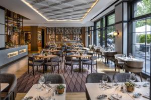 a restaurant with tables and chairs and windows at DoubleTree by Hilton Berlin Ku'damm in Berlin