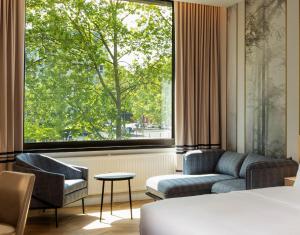 a hotel room with a bed and a large window at DoubleTree by Hilton Berlin Ku'damm in Berlin +82 photos