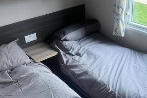 a bedroom with a bed and a desk next to a window at Caravan- Sleeps 6 2 Bedrooms - Thurston Manor in Dunbar
