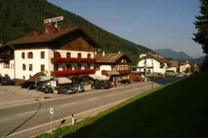 a building on the side of a road next to a mountain at Hotel International in Tarvisio