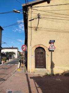 a building with a door on the side of a street at Studio cosy Proche Lyon Arrivée autonome in Cailloux-sur-Fontaines