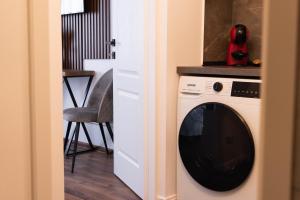 a washing machine in a room with a chair at Ghetto Experience - Self Check-In - Usa cu Cod in Vaslui