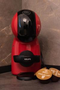 a red coffee maker with a helmet on top of it at Ghetto Experience - Self Check-In - Usa cu Cod in Vaslui