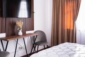 a bedroom with a table and two chairs and a bed at Ghetto Experience - Self Check-In - Usa cu Cod in Vaslui