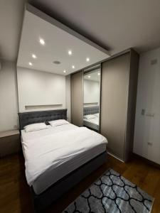 a bedroom with a large bed and a large window at Eden apartments in Tivat