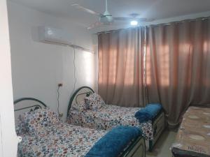 a bedroom with two beds in front of a window at شقة فاخرة موقع ممتاز in Aswan