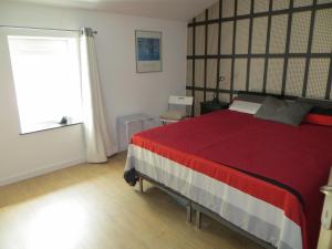 a bedroom with a large bed with a red blanket at Les Lilas in Saint-Clair +11 photos