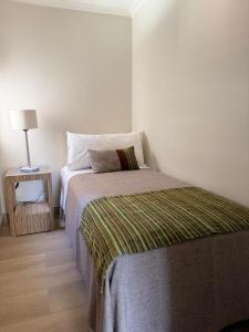 a bedroom with a bed and a side table with a lamp at RQ Costanera Apartments in Santiago