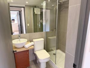 a bathroom with a toilet and a sink and a shower at RQ Costanera Apartments in Santiago +25 photos