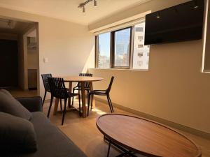 a living room with a table and chairs and a couch at RQ Costanera Apartments in Santiago