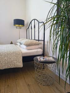 a bedroom with a bed and a plant and a table at Apartament Wieżyczka in Świdnica +9 photos