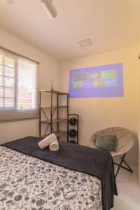 a bedroom with a bed and a window and a chair at Golden Pipa House in Pipa