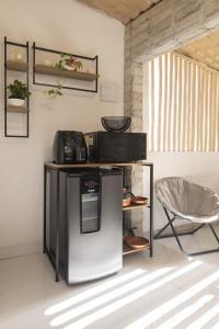 a refrigerator and a chair in a room at Golden Pipa House in Pipa