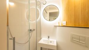 a bathroom with a shower and a sink and a mirror at Premiere Classe Orleans Nord - Saran in Saran +19 photos