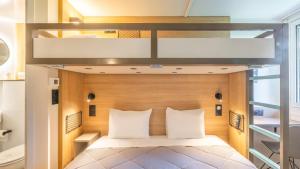 a bedroom with a bunk bed and two loft beds at Premiere Classe Orleans Nord - Saran in Saran