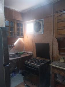 a small kitchen with a stove and a sink at شقة فاخرة موقع ممتاز in Aswan