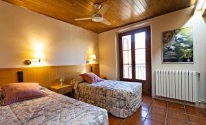 a hotel room with two beds and a window at Hostal Victor in Oliana
