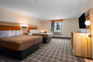 a hotel room with two beds and a flat screen tv at All Seasons Resort in Kalkaska +64 photos