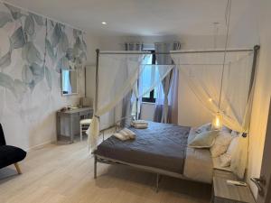 a bedroom with a canopy bed and a desk at Villa BRUNI Wine Guest House in Montefalco