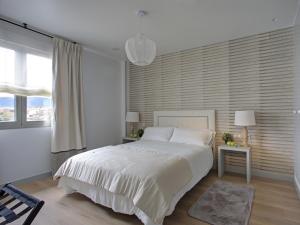a white bedroom with a large bed and a window at Hotel Faisanera Golf in Palazuelos de Eresma