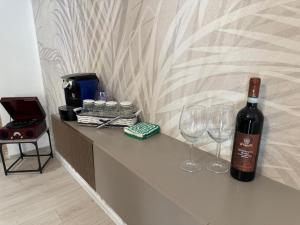 a bottle of wine and two wine glasses on a counter at Villa BRUNI Wine Guest House in Montefalco
