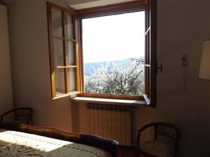 a bedroom with a window with a snow covered tree at Villa Rocca in Marciaga