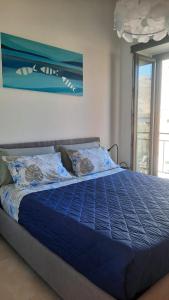 a blue bed with a blue comforter in a bedroom at Palazzo Sandù Dimora nel Borgo in San Nicola Arcella