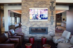 a lobby with a fireplace and chairs and a tv at Four Points by Sheraton Midland in Midland