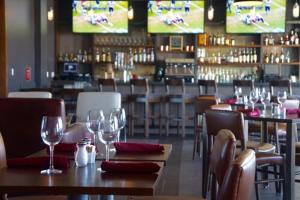 a restaurant with tables and chairs with wine glasses at Four Points by Sheraton Midland in Midland