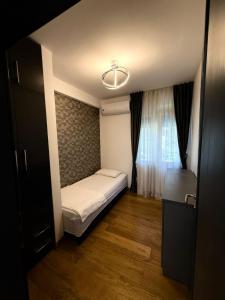 a small bedroom with a bed and a window at Eden apartments in Tivat