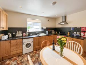 a kitchen with a table and a washing machine at Uk47551 - Cree View Cottage in Newton Stewart