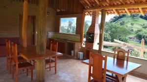a dining room with a table and chairs and a fireplace at Pousada Dona Manoela in Gonçalves