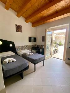 a room with two beds and a sliding glass door at Addauro Resort in Syracuse