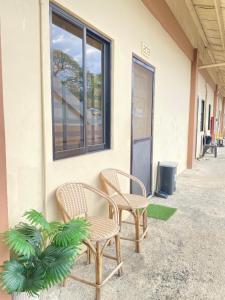 two chairs sitting outside of a building at ZK Homestay in Puerto Princesa City
