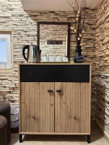a wooden cabinet with a kettle on top of it at Guest house Kozle in Skopje