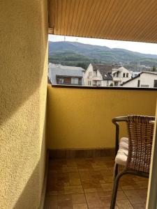 a chair sitting on a balcony looking out a window at Guest house Kozle in Skopje