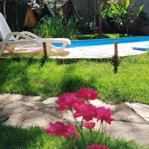 a yard with pink flowers and a swimming pool at Recanto da Filó Serra do Cipó in Serra do Cipo