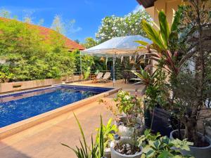 a swimming pool with plants and an umbrella at SAMUI BOHO Family Villa 4BR with Pool Renovated 2026 in Nathon Bay